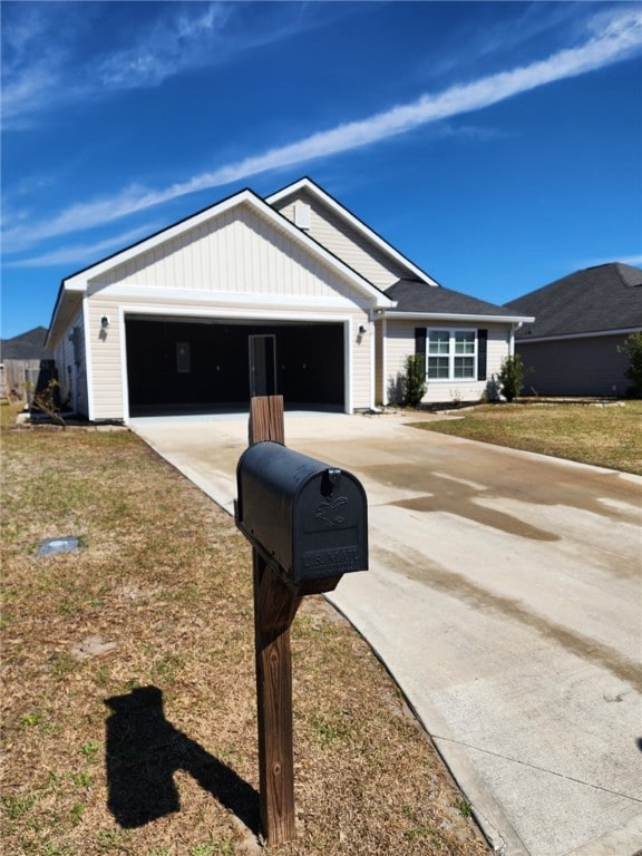 view of front of house featuring a garage, concrete driveway, and a front yard