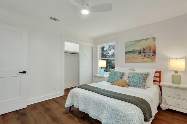 bedroom with dark wood-type flooring, ceiling fan, and a closet