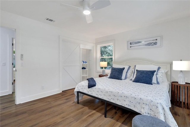 bedroom with dark hardwood / wood-style flooring and ceiling fan