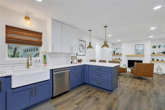 kitchen featuring sink, decorative light fixtures, stainless steel dishwasher, kitchen peninsula, and white cabinets