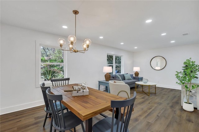 dining space with a healthy amount of sunlight, a notable chandelier, and dark hardwood / wood-style flooring