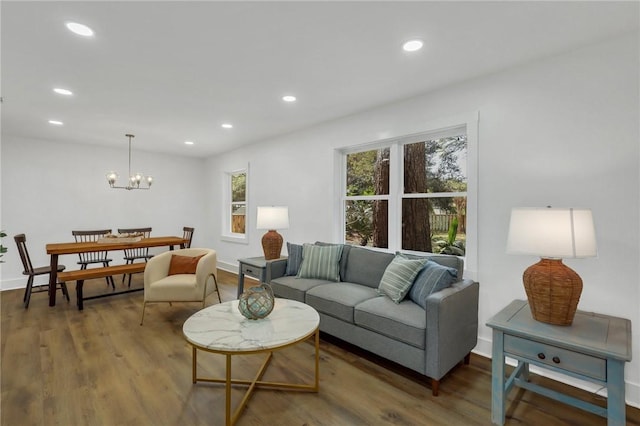 living room with a notable chandelier and dark hardwood / wood-style flooring