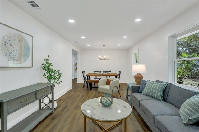 living room with dark hardwood / wood-style flooring and an inviting chandelier