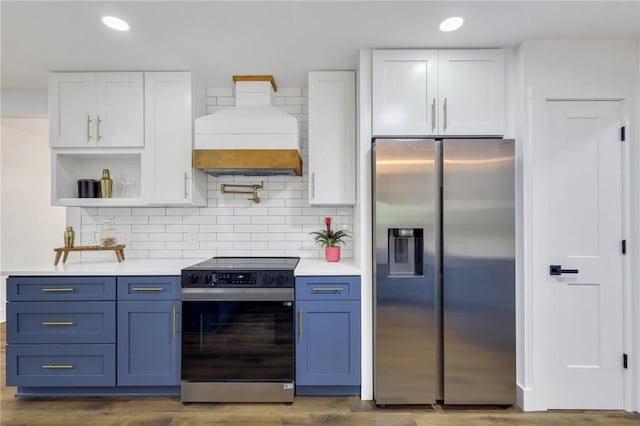 kitchen featuring appliances with stainless steel finishes, blue cabinets, custom exhaust hood, and white cabinets