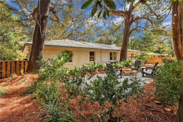 rear view of house with an outdoor fire pit and a patio area