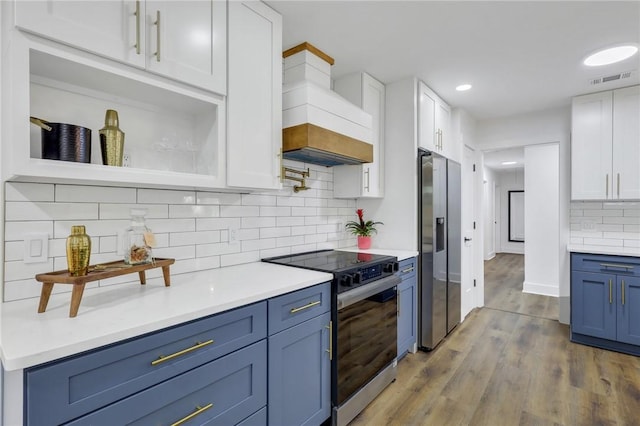 kitchen with blue cabinetry, light wood-type flooring, custom range hood, stainless steel appliances, and white cabinets