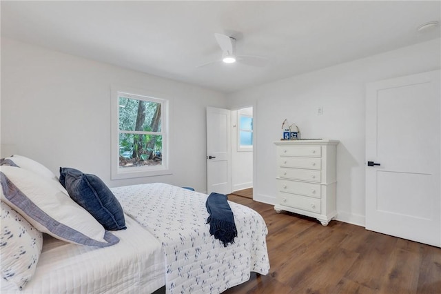 bedroom with dark hardwood / wood-style flooring and ceiling fan