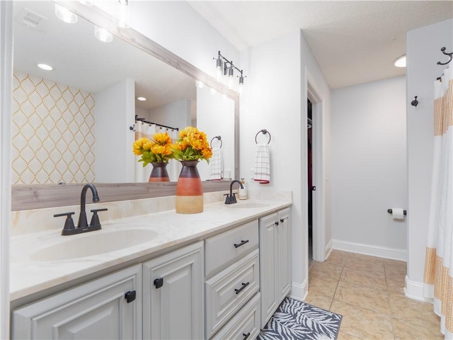 bathroom featuring double vanity, tile patterned flooring, a sink, and visible vents