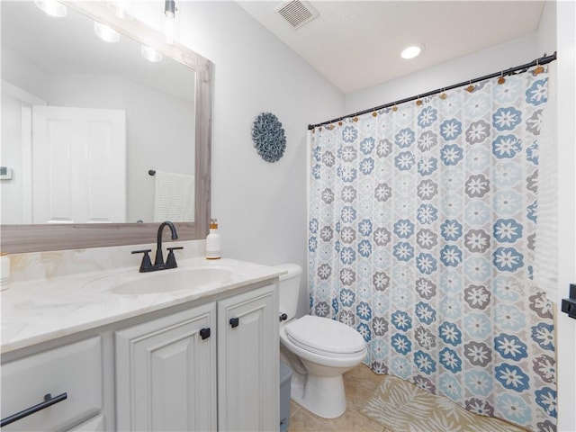 bathroom featuring visible vents, toilet, vanity, a shower with curtain, and tile patterned floors