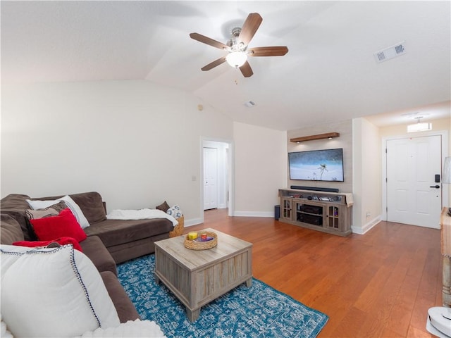 living area with visible vents, a ceiling fan, vaulted ceiling, wood finished floors, and baseboards