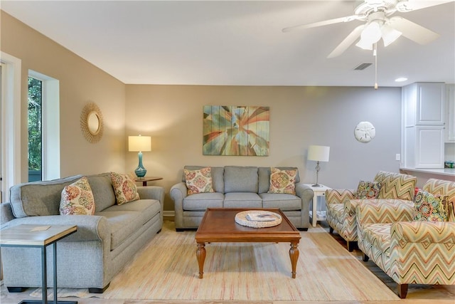 living room with light hardwood / wood-style floors and ceiling fan