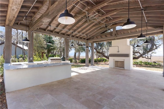 view of patio with area for grilling, ceiling fan, exterior kitchen, a gazebo, and an outdoor fireplace