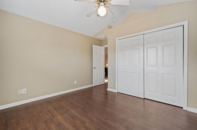 unfurnished bedroom with ceiling fan, a closet, dark wood-type flooring, and vaulted ceiling