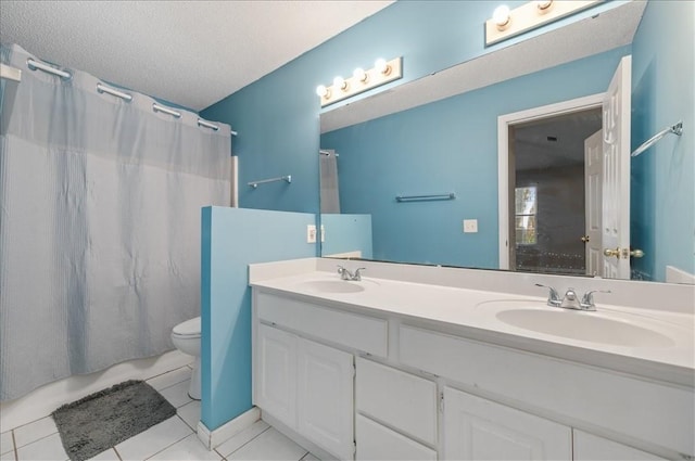 bathroom with tile patterned flooring, vanity, toilet, and a textured ceiling