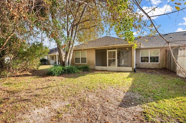 rear view of house with a sunroom and a lawn