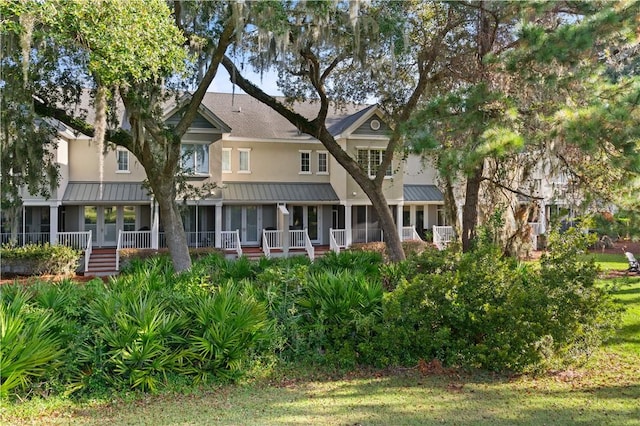 exterior space featuring a standing seam roof, a front lawn, and metal roof