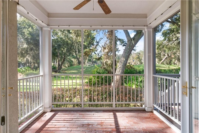 unfurnished sunroom featuring a ceiling fan