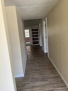 hall with dark wood-style floors and baseboards