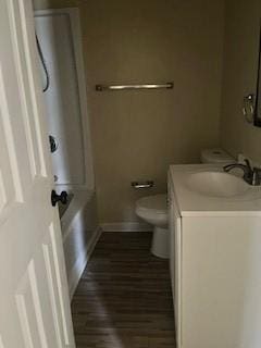 bathroom featuring toilet, wood finished floors, baseboards, bathtub / shower combination, and vanity