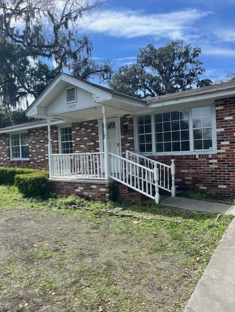 view of front of property featuring covered porch and brick siding