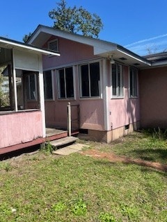 view of property exterior with crawl space, a yard, and a sunroom