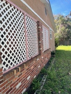 view of home's exterior with a lawn and brick siding