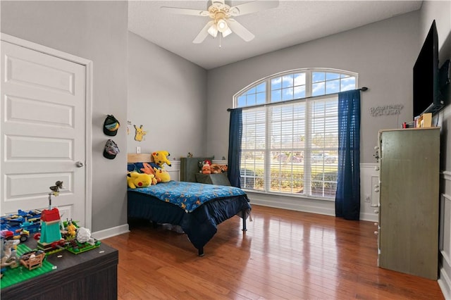 bedroom with ceiling fan, baseboards, and wood finished floors