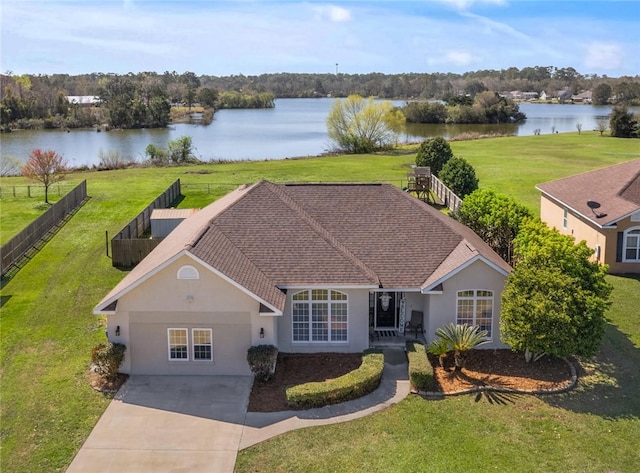 view of front of house featuring stucco siding, a water view, a front yard, and fence