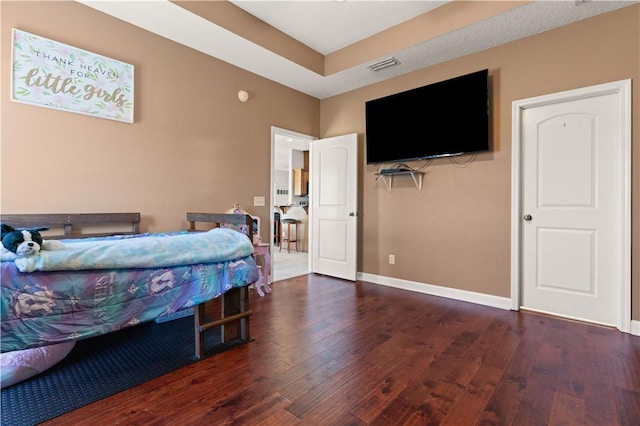 bedroom with visible vents, baseboards, and hardwood / wood-style floors