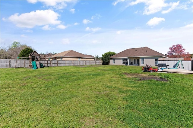 view of yard with a patio, a playground, and a fenced backyard