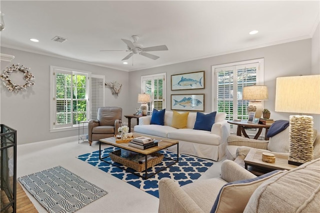 living room with ceiling fan, ornamental molding, carpet floors, and a wealth of natural light