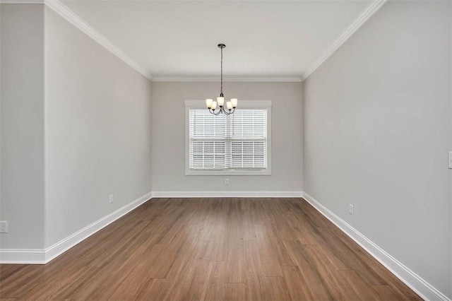 spare room with an inviting chandelier, crown molding, and wood-type flooring