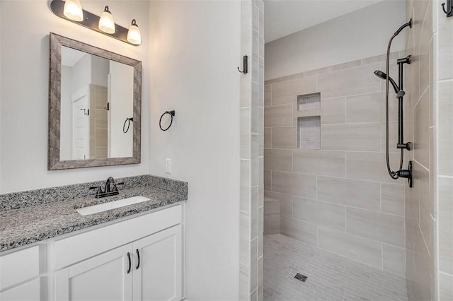 bathroom with vanity and tiled shower