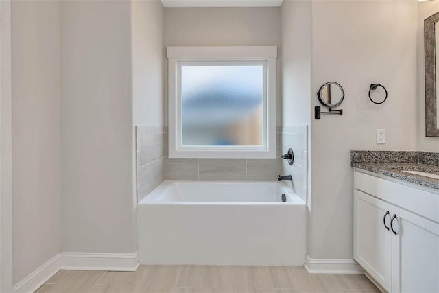 bathroom with vanity and a tub