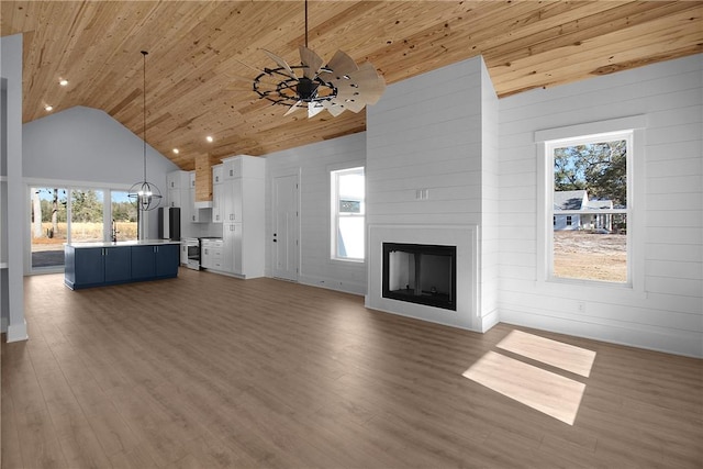 unfurnished living room with ceiling fan, wooden ceiling, a fireplace, and wood finished floors