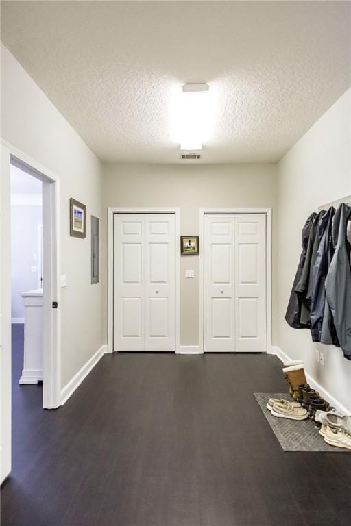 mudroom with a textured ceiling, dark hardwood / wood-style flooring, and electric panel