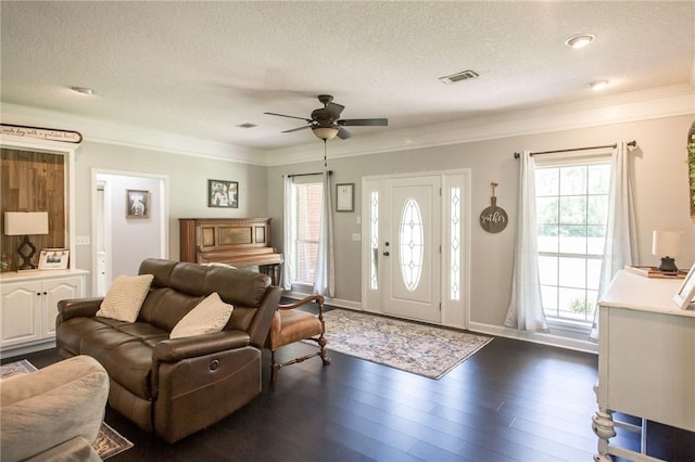 living room featuring ceiling fan, dark wood-type flooring, a textured ceiling, and crown molding