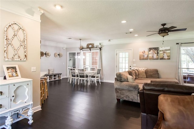 living room featuring ceiling fan, dark wood-type flooring, plenty of natural light, and crown molding