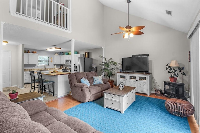 1020 NE Pine Point Ln, Townsend, GA 31331 - living room with ceiling fan, high vaulted ceiling, light wood-type flooring, and a wood stove