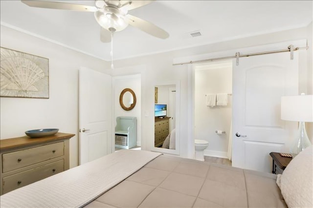 bedroom featuring ensuite bath, ceiling fan, and a barn door