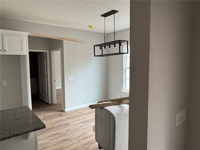 dining area with a textured ceiling and light hardwood / wood-style flooring