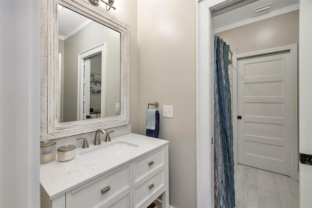 bathroom with ornamental molding, vanity, and hardwood / wood-style floors