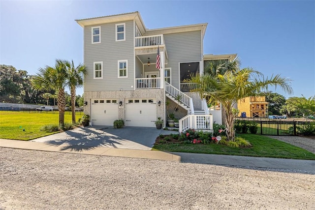 view of front facade with a garage, a balcony, a front yard, and covered porch