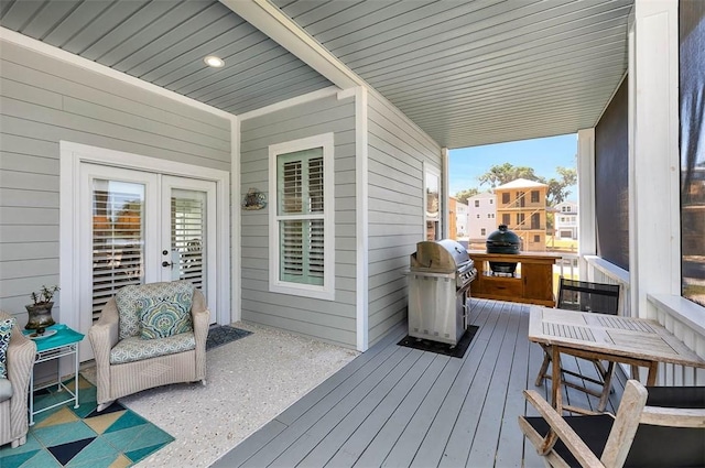 wooden terrace with area for grilling and french doors