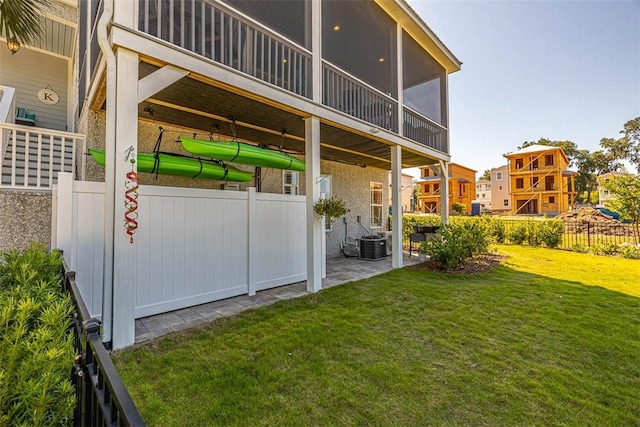 rear view of house featuring a patio, a sunroom, and a yard