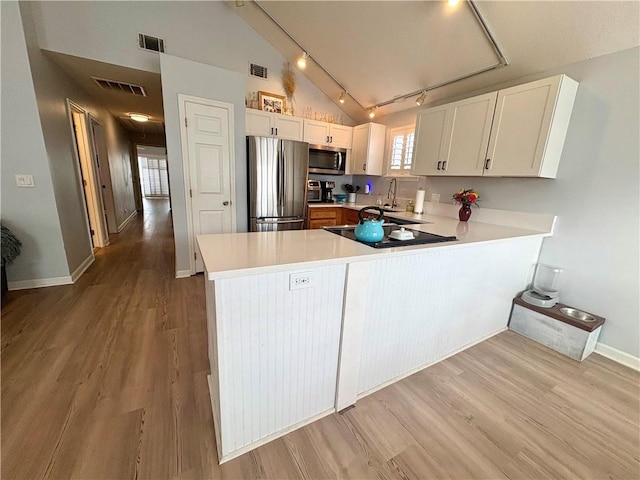 kitchen with visible vents, white cabinets, appliances with stainless steel finishes, a peninsula, and light countertops