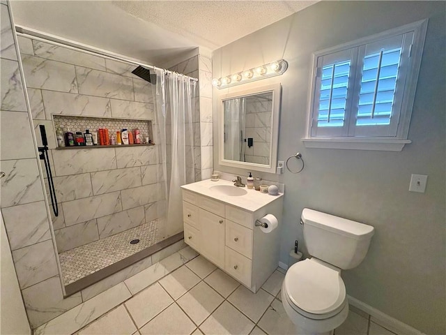 bathroom with a tile shower, vanity, toilet, and a textured ceiling