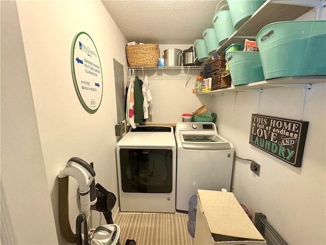 washroom featuring laundry area, a textured ceiling, and washer and dryer