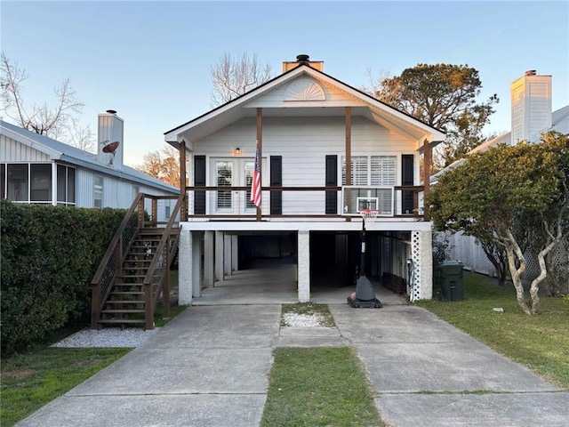 view of front facade with a carport, driveway, and stairway