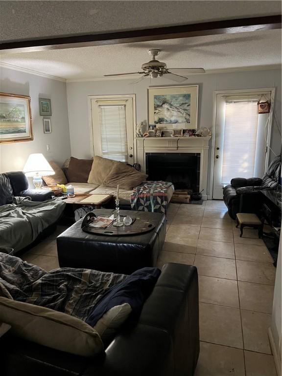 living room with ceiling fan, crown molding, light tile patterned flooring, and a textured ceiling